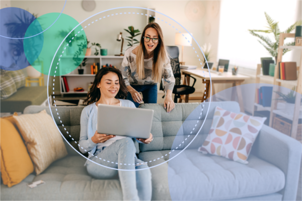 Get more ecommerce sales through referrals | a woman on the couch shows something on her laptop to her friend, standing nearby